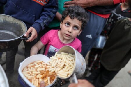 Gaza kämpft gegen den Hunger: Kinder stehen Schlange, um eine Schüssel mit Essen zu bekommen